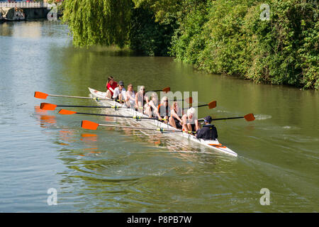 Ein 8 person Ruderboot mit Frauen Rudern auf dem Fluss Cam an einem sonnigen Tag Sommer, Cambridge, Großbritannien Stockfoto