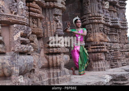 Odissi ist eines der acht klassischen Tanzformen Indiens, vom Zustand von odisha. Hier die Tänzerin stellt sich vor Tempeln mit Skulpturen Stockfoto