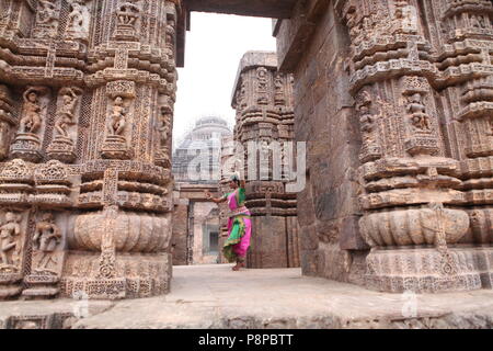 Odissi ist eines der acht klassischen Tanzformen Indiens, vom Zustand von odisha. Hier die Tänzerin stellt sich vor Tempeln mit Skulpturen Stockfoto