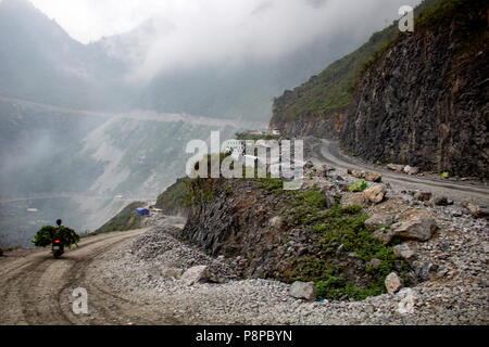 Ha Giang, Vietnam - am 18. März 2018: Motorrad Transport landwirtschaftlicher Güter auf einer asphaltierten Straße zwischen den mountans im Norden von Vietnam Stockfoto