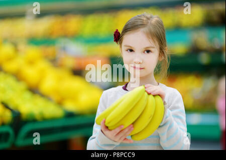 Süße kleine Mädchen, dass Bananen in einem Kaufhaus oder Supermarkt. Stockfoto