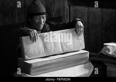 TIBETISCHEN buddhistischen Mönch mit heiligen Texte in das Dorf SAMDO auf der ganzen MANASLU Trekking - NUPRI REGION NEPALS Stockfoto