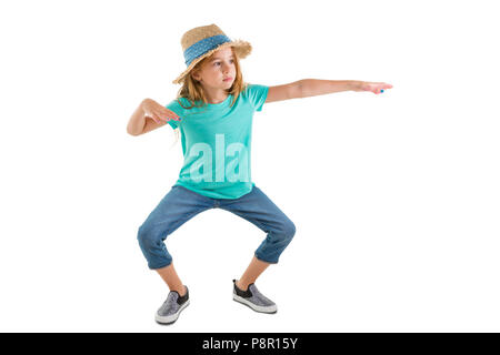 Junge Mädchen in lässigen Jeans und einen Strohhut stehend, funky Dance Moves biegen am Knie mit ausgestreckten Armen isoliert auf weißem Stockfoto