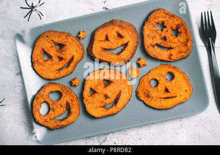 Gebratene Kartoffel Schnitzen lustige Gesichter, Halloween Symbol kreative Essen für Kinder Stockfoto