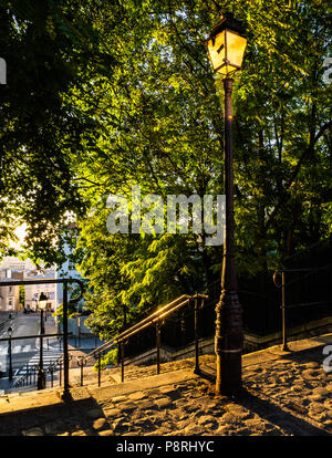 Ein Paris Street Scene bei Sonnenaufgang in Montmartre mit Kopfsteinpflaster und verzierten lamposts Stockfoto