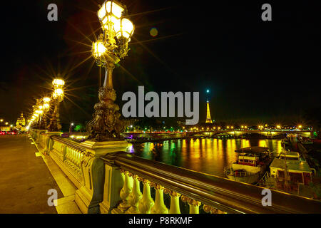 Paris leuchtet auf in Pont Alexandre III Brücke mit brennenden Lampen. Französische europäische Hauptstadt mit den Eiffelturm und Paris night skyline in Frankreich. Nacht städtische Szene. Stockfoto