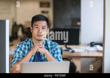 Junge Designer an seinem Schreibtisch in einem Büro arbeiten konzentriert Stockfoto