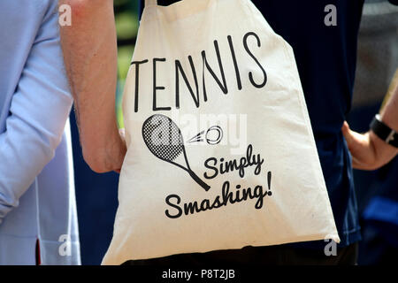 Ein Zuschauer eine Tasche lesen Tennis einfach Smashing am Tag elf der Wimbledon Championships in der All England Lawn Tennis und Croquet Club, Wimbledon. PRESS ASSOCIATION Foto. Bild Datum: Freitag, 13. Juli 2018. Siehe PA Geschichte TENNIS Wimbledon. Photo Credit: Nigel Französisch/PA-Kabel. Einschränkungen: Nur für den redaktionellen Gebrauch bestimmt. Keine kommerzielle Nutzung ohne vorherige schriftliche Zustimmung der AELTC. Standbild nur verwenden - keine bewegten Bilder zu emulieren. Keine Überlagerung oder Entfernung von Sponsor/ad Logos. +44 (0)1158 447447 für weitere Informationen. Stockfoto