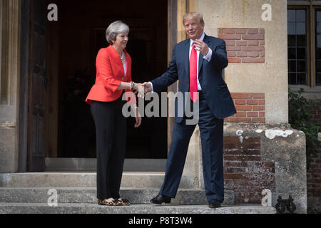 Premierminister Theresa May begrüßt uns Präsident Donald Trump vor der Haustür in Chequers, nachdem er für Gespräche, die auf ihr Land Residence in Buckinghamshire angekommen. Stockfoto