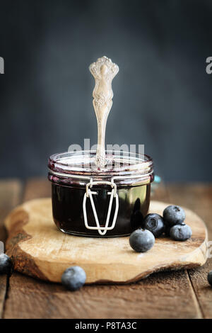 Hausgemachten blueberry konserviert in einem canning Glas Kaution jar mit antiken Löffel. Extrem flache Tiefenschärfe mit selektiven Fokus auf Jam. Stockfoto