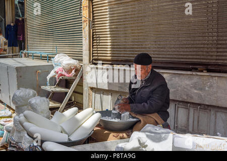 Sanandaj, Iran - 3. April 2018: Die iranischen Mann stürzt Zucker Kegel für Verkauf im Basar. Provinz Kurdistan Stockfoto