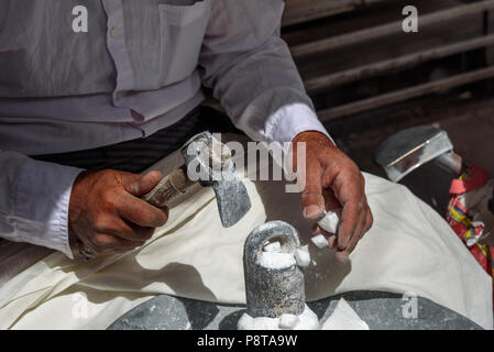 Sanandaj, Iran - 3. April 2018: Die iranischen Mann stürzt Zucker Kegel für Verkauf im Basar. Provinz Kurdistan Stockfoto