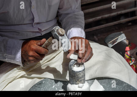 Sanandaj, Iran - 3. April 2018: Die iranischen Mann stürzt Zucker Kegel für Verkauf im Basar. Provinz Kurdistan Stockfoto