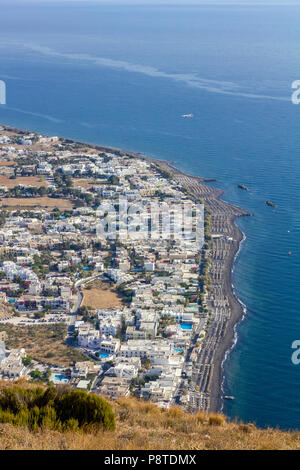 Erhöhte Landschaft Szene auf der Insel Santorini. Kamari, Griechenland, von oben. Erstaunlich tagsüber teilweise Blick auf die bunte Stadt und den Strand und das Meer in Stockfoto