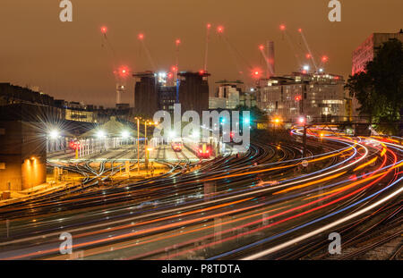 Nacht Blick von Ebury Bridge in Richtung dekonstruiert Battersea Power Station, London, mit leichten Wanderwegen der Züge nach und von der Victoria Station Stockfoto