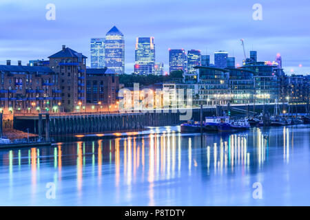 Vor Sonnenaufgang Blick vom Tower Bridge in Richtung der beleuchteten Gebäuden von Canary Wharf, London, mit Lichtern in der Themse wider Stockfoto