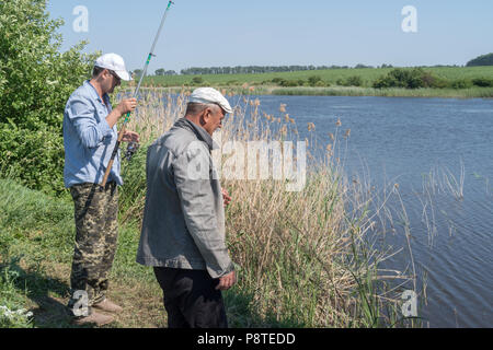 Männer Angeln am Teich genießen. Stockfoto