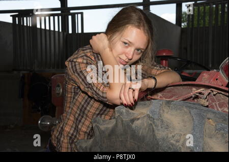 Blonde Dame am Traktor Stockfoto