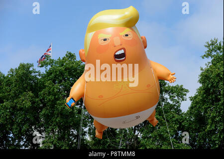 London, Großbritannien. 13. Juli 2018. Ein riesiger "Trump Baby' Ballon fliegt über Parliament Square in Westminster als Teil einer Protest gegen Präsident Donald Trump Besuch in Großbritannien. Veranstalter haben die 6 m hohen BLIMP entwickelt, Fliegen in einer Höhe von 30 m, das Donald Trump als Baby mit kleinen Händen, mit Handy und trug eine Windel. Massenproteste werden voraussichtlich auch im Zentrum von London, in Reaktion auf den Besuch des Präsidenten. Credit: Stephen Chung/Alamy leben Nachrichten Stockfoto