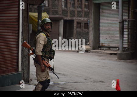 Juli 13, 2018 - Srinagar, Jammu und Kaschmir, Indien - Indische paramilitärische Soldaten Wache während der Ausgangssperre in Srinagar, Indisch kontrollierten Teil Kaschmirs am Freitag. Juli 13 ist als Märtyrer' Tag in Erinnerung an den Tag beobachtet, wenn Hinduistische König der Region bestellt mehr als 20 kaschmirische Muslime in einem Angebot, einem Aufstand 1931, ausgeführt. Regierung verhängt Ausgangssperre in Teile von Srinagar nach separatistischen Gruppen für März zu Märtyrer Friedhof in Erinnerung an den Tag am Freitag. Credit: Abbas Idrees/SOPA Images/ZUMA Draht/Alamy leben Nachrichten Stockfoto