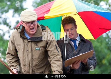 Builth Wells, Powys, UK. 13. Juli 2018. Auktionatoren und Schafhalter kommen für den Regen mit regenjacken bei der wöchentlichen Schafmarkt in Builth Wells, Powys, Wales, UK vorbereitet. © Graham M. Lawrence/Alamy Leben Nachrichten. Stockfoto