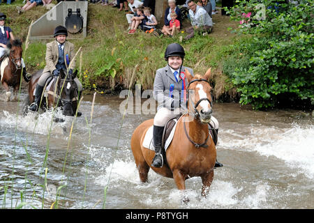 JEDBURGH, Schottland - Juli 13: Jethart Callant's Festival - Festival Tag eine junge Reiterin Furten der Jed Wasser während der Jethart Callant's Festival, ein jährliches Festival, Teil der schottischen Grenze gemeinsame Reiten Saison. Festival Tag am Juli 13, 2018 in Jedburgh. Jethart Callant 2018 Nick Arnold (72Nd Jethart Callant) führte über 200 Reiter (Foto von Rob Grau/Freiberufler) Stockfoto