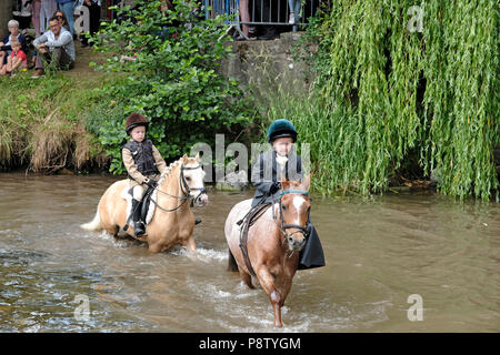 JEDBURGH, Schottland - Juli 13: Jethart Callant's Festival - Festival Tag Ponys und junge Fahrer Ford der Jed Wasser während der Jethart Callant's Festival, ein jährliches Festival, Teil der schottischen Grenze gemeinsame Reiten Saison. Festival Tag am Juli 13, 2018 in Jedburgh. Jethart Callant 2018 Nick Arnold (72Nd Jethart Callant) führte über 200 Reiter (Foto von Rob Grau/Freiberufler) Stockfoto