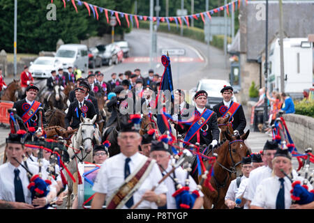 JEDBURGH, Schottland - Juli 13: Jethart Callant's Festival - Festival Tag Jethart Callant 2018 Nick Arnold (72Nd Jethart Callant) führt die montiert Kavalkade von Pferden zusammen mit Linken Mann Gary Hogg und Rechter Mann Brodie Irvine, vom ehemaligen Callant während des Jethart Callant's Festival, ein jährliches Festival, Teil der schottischen Grenze gemeinsame Reiten Saison folgte. Festival Tag am Juli 13, 2018 in Jedburgh. Da sie in der Nähe der Ruinen der Jedburgh Abbey und die Städte War Memorial (Foto von Rob Grau/Freiberufler) Stockfoto