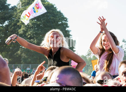 Junge Festivalbesucher Genießen der Musik Freunde, sitzen auf den Schultern in der Masse, am Obelisken Bühne Latitude Festival, henham Park, Suffolk, England, 13. Juli 2018. Stockfoto