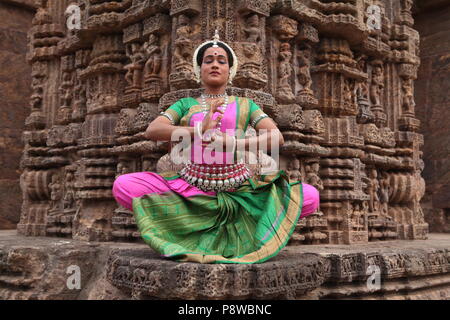 Odissi ist eines der acht klassischen Tanzformen Indiens, vom Zustand von odisha. Hier die Tänzerin stellt sich vor Tempeln mit Skulpturen Stockfoto