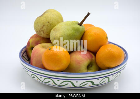 Schale mit Obst, Orangen, Äpfel und Birnen in einem keramischen bemalte Schale Stockfoto