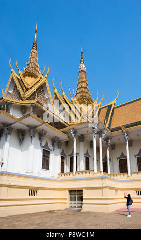 Eine Touristenfrau fotografiert die atemberaubende Thronhalle im Königlichen Palast von Phnom Penh, Kambodscha, kulturelles Erbe und architektonische Schönheit, vertikal Stockfoto