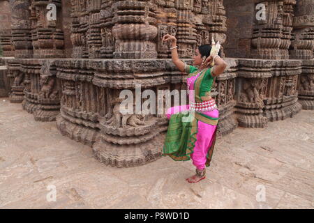 Odissi ist eines der acht klassischen Tanzformen Indiens, vom Zustand von odisha. Hier die Tänzerin stellt sich vor Tempeln mit Skulpturen Stockfoto