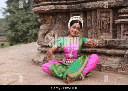 Odissi ist eines der acht klassischen Tanzformen Indiens, vom Zustand von odisha. Hier die Tänzerin stellt sich vor Tempeln mit Skulpturen Stockfoto