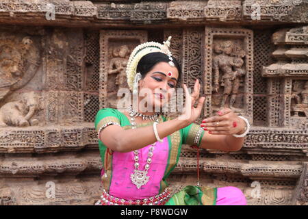 Odissi ist eines der acht klassischen Tanzformen Indiens, vom Zustand von odisha. Hier die Tänzerin stellt sich vor Tempeln mit Skulpturen Stockfoto