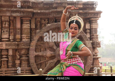 Odissi ist eines der acht klassischen Tanzformen Indiens, vom Zustand von odisha. Hier die Tänzerin stellt sich vor Tempeln mit Skulpturen Stockfoto