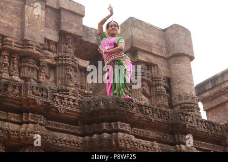 Odissi ist eines der acht klassischen Tanzformen Indiens, vom Zustand von odisha. Hier die Tänzerin stellt sich vor Tempeln mit Skulpturen Stockfoto