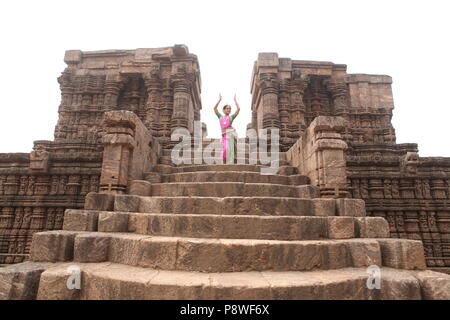 Odissi ist eines der acht klassischen Tanzformen Indiens, vom Zustand von odisha. Hier die Tänzerin stellt sich vor Tempeln mit Skulpturen Stockfoto