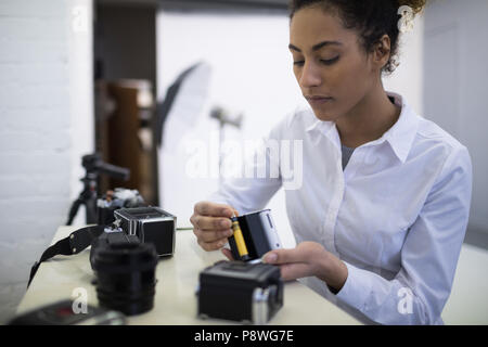 Fotografin entfernen Haspel von der Digitalkamera Stockfoto