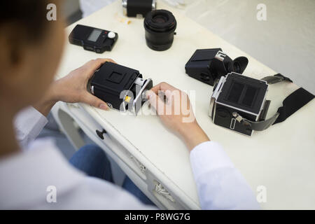 Fotografin entfernen Haspel von der Digitalkamera Stockfoto