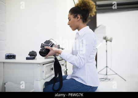 Fotografin entfernen Haspel von der Digitalkamera Stockfoto