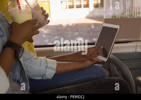 Zwillinge Geschwister mit digitalen Tablet im Bus Stockfoto