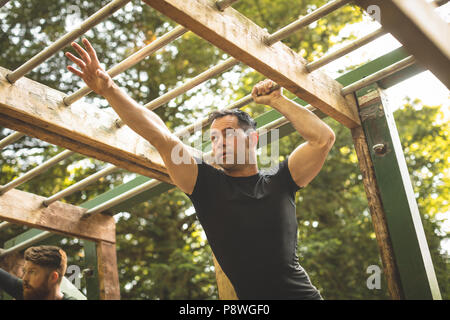 Passen Mann klettern Monkey Bars Stockfoto