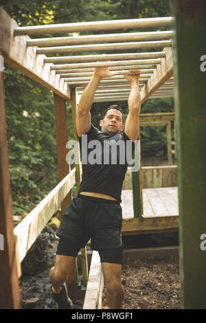 Passen Mann klettern Monkey Bars Stockfoto