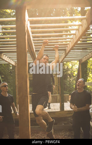 Passen Mann klettern Monkey Bars Stockfoto