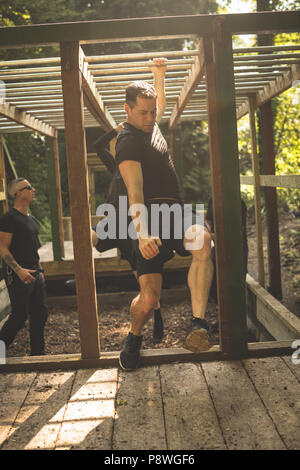 Passen Mann klettern Monkey Bars Stockfoto