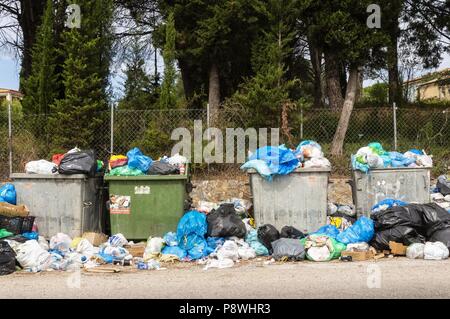 Müllcontainer und Müllsäcke sind auf der griechischen Insel Korfu am Straßenrand | Verwendung weltweit Stockfoto