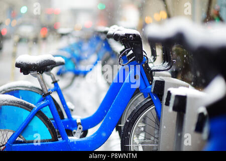 Zeile der Miete City Bikes bei Docking Station mit Schnee in New York im Winter abgedeckt Stockfoto