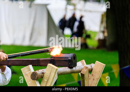Ein frühes Beispiel eines deutschen Nahbereich hand Cannon ruht auf Holz- Unterstützung bei der Sicherung leuchtet in mittelalterlichen Re-enactment Veranstaltung am Sandwich Stockfoto