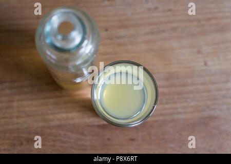 Ansicht von oben mit Glas und Flasche mit der Klärung, entschlacken Apfelessig für die Immunabwehr auf hölzernen Tisch Stockfoto